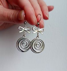 The earrings are decorated with pendants in the shape of a round spiral and a small bow . The earrings are fastened with stainless steel  hooks. Earring length - 3.0 cm (1.2 inches) Earrings are packed in a gift box RECOMMENDATIONS FOR CARE: Do not wet, do not drop, and store in a dark box! - Remove jewelry before exercising, swimming, showering and sleeping. - Avoid contact with moisture such as make-up, moisturizer, lotion, perfume and hairspray. - Store your jewelry in a box or pouch after us Grunge Earrings Piercings, Quirky Accessories, Grunge Earrings, Earrings Y2k, Downward Spiral, Silver Wire Earrings, Style Indie, Spiral Galaxy, Indie Grunge