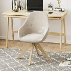 a chair sitting in front of a laptop computer on top of a wooden desk next to a white wall