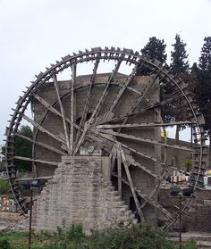 an old water wheel sitting in the middle of a field