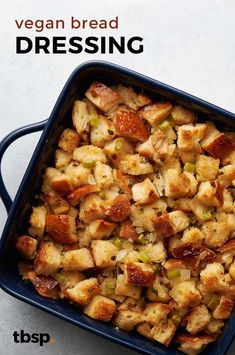 a blue casserole dish filled with bread and stuffing