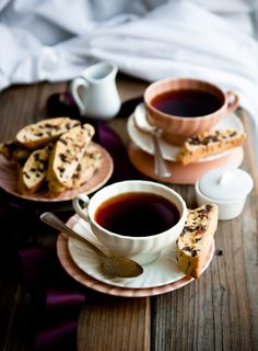 two cups of tea and some cookies on a table