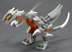 an orange and white lego dragon with horns on it's back legs, standing upright