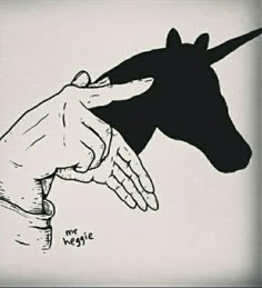 a drawing of a hand reaching for a unicorn's head