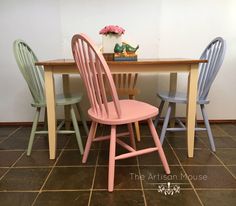 three wooden chairs sitting at a table with a vase on top of it and a potted plant in the background