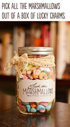 a jar filled with marshmallows sitting on top of a table next to a book shelf