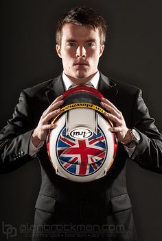 a man in a suit holding a soccer ball with the british flag on it's side