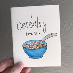 a hand holding up a card with cereal in a blue bowl and the words'cereally love you'written on it