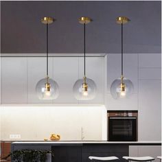 three lights hanging from the ceiling in a kitchen