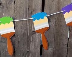 some paint brushes are hanging on a clothes line