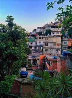 an urban area with lots of buildings and trees in the foreground, surrounded by greenery