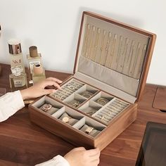 a woman is sitting at a table with an open jewelry box