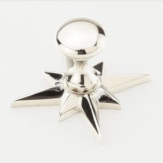 a metal star shaped object on a white surface