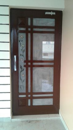 the front door is decorated with flowers and leaves on it's glass paneling