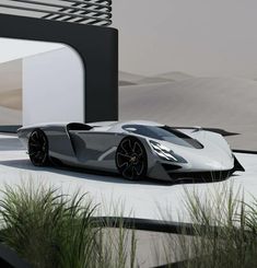 a white and black sports car parked in front of a building with tall grass on the ground