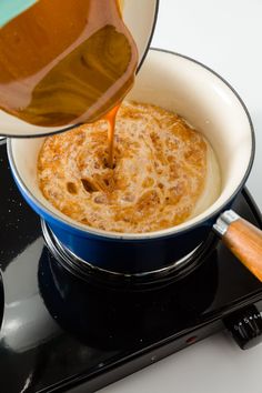 someone is pouring something into a bowl on top of the burner and it's being stirred