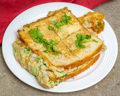 a white plate topped with two pieces of toasted bread covered in cheese and greens