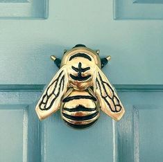 a close up of a metal door handle on a blue door with a bee design