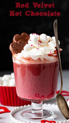 a red velvet hot chocolate in a glass with marshmallows and candy on top