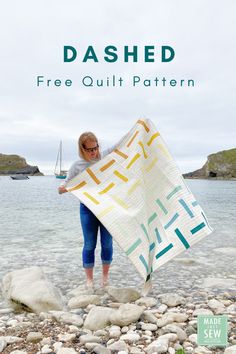 a woman holding a quilt on the beach with text that reads dashed free quilt pattern