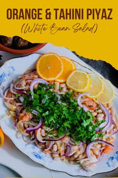 an orange and tahiti piya salad on a plate with lemons, parsley