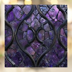 a purple and black stained glass window with wavy lines in the center, surrounded by small rocks