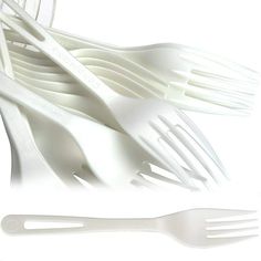 white plastic utensils are stacked on top of each other with forks in them