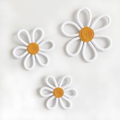 three white and orange flowers on a white surface