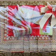 a red and white gift box filled with assorted items for someone's wedding