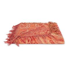 an orange and red paisley throw with fringes on the edges, in front of a white background