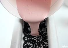 a close up of a blender with pink liquid on it's handle and black doily