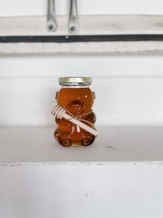 a glass jar filled with honey sitting on top of a counter