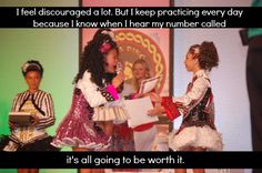 two girls in costumes are talking to each other on stage with one holding a piece of paper