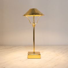 a gold colored lamp on a marble surface