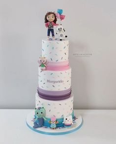 a three tiered cake decorated with sprinkles and a doll on top