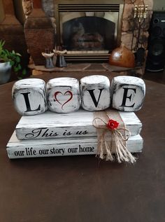 love blocks are stacked on top of each other in front of a fire place with a bow