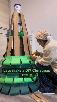 a woman is making a diy christmas tree out of cardboard