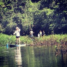 a woman standing on top of a paddle board in the water