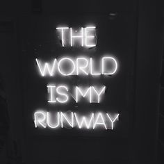 a neon sign that says the world is my runway in white letters on a black background