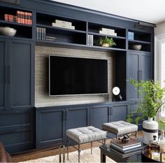 a living room with built in bookshelves and a flat screen tv on the wall