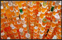 many orange bottles are stacked up together