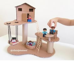 a person is playing with some toys on a white table and it looks like they are building a house