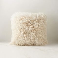 a fluffy white pillow sitting on top of a table