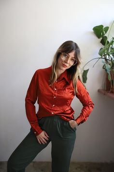 DETAILS:: //  Vintage 1990s long sleeve button down rust red blouse. Silky smooth, luxurious feel. great wardrobe staple / layering piece! good vintage condition, light wear. no holes or stains.  Out of the Blue medium  95% Silk 5% Lycra Check the measurements and model information to see if this would be a good fit for you!  Measurements are taken flat in inches and doubled at the bust, waist and hips. On some pieces I provide two sets of measurements on the bust waist and hips. First measurement is taken unstretched and the second stretched to show how much the material stretches and it's size versatility. Sleeve width is taken flat at the shoulder, measuring the width of the armholes. Please convo me if you need additional measurements!  Measurements //  Sleeve length: 23.5" Sleeve widt Rust Colored Satin Shirt, Retro Orange Long Sleeve Blouse, Vintage Orange Long Sleeve Blouse, Casual Orange Button-up Blouse, Orange Button-up Cotton Blouse, Red Blouses, Layering Pieces, Burnt Orange, Silk Blouse