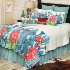 a bed with a cactus and flowers quilt on it, along with two nightstands