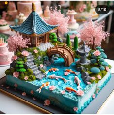 a cake decorated with flowers, trees and a bridge over a pond in the shape of a japanese garden