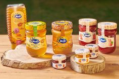 several jars of honey sit on a wooden table