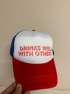 Head out in style with the Drinks Well With Others trucker hat! This one-of-a-kind, tri-colored design looks and feels awesome, so you can make a statement without saying a word. Plus, the adjustable snapback ensures everyone can enjoy this fashionable accessory. Get ready to turn heads! Funny Trucker Hat, One Size Fits Most, Funny Trucker Hat One Size, Funny Snapback Trucker Hat, Funny One Size Fits Most Trucker Cap, Funny Trucker Hat With Letter Print, Funny White Trucker Hat Baseball Cap, Funny White Baseball Cap Trucker Hat, Funny Trucker Hat With Curved Brim, Funny Letter Print Trucker Hat