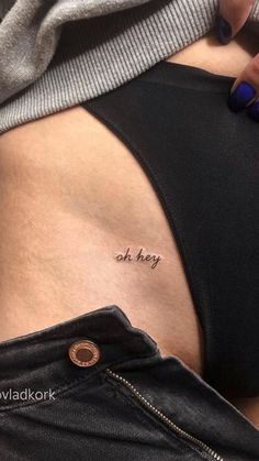 a woman's stomach with the word oh hey written on her lower back tattoo