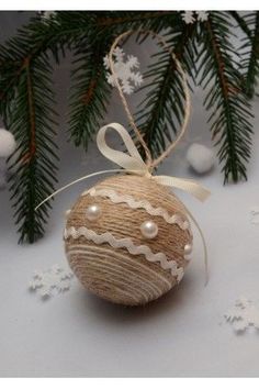 an ornament hanging from a christmas tree with snowflakes on the ground