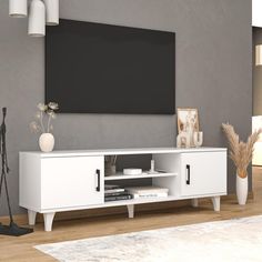 a white entertainment center with a flat screen tv mounted on it's sideboard